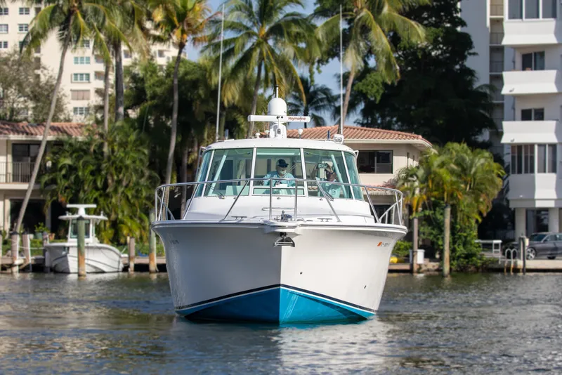 Slide: The Image of 2015 Albemarle 360 Express Fisherman boat on water, surrounded by palm trees and buildings. - 2