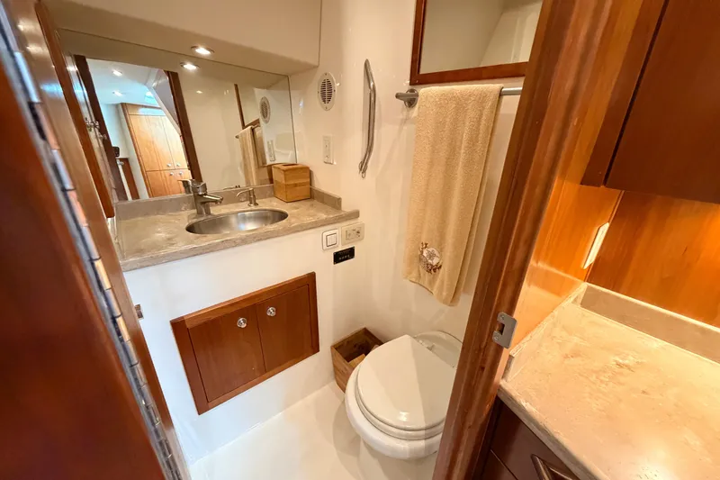 Slide: The Image of Bathroom interior of 2015 Albemarle 360 Express Fisherman, featuring sink, toilet, and wooden cabinetry. - 62