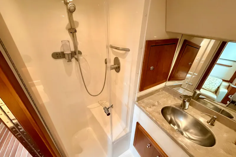 Slide: The Image of 2015 Albemarle 360 Express Fisherman bathroom with shower, sink, and wooden cabinets. - 63