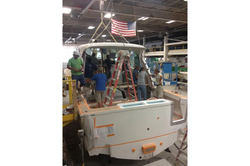 Slide: The Image of Workers assembling a 2015 Albemarle 360 Express Fisherman boat in a factory setting. - 88