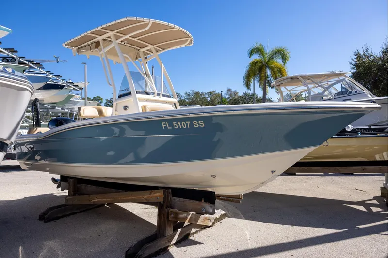 The Image of 2020 Scout 195 Sportfish boat on display, blue hull, palm trees in background. - 0