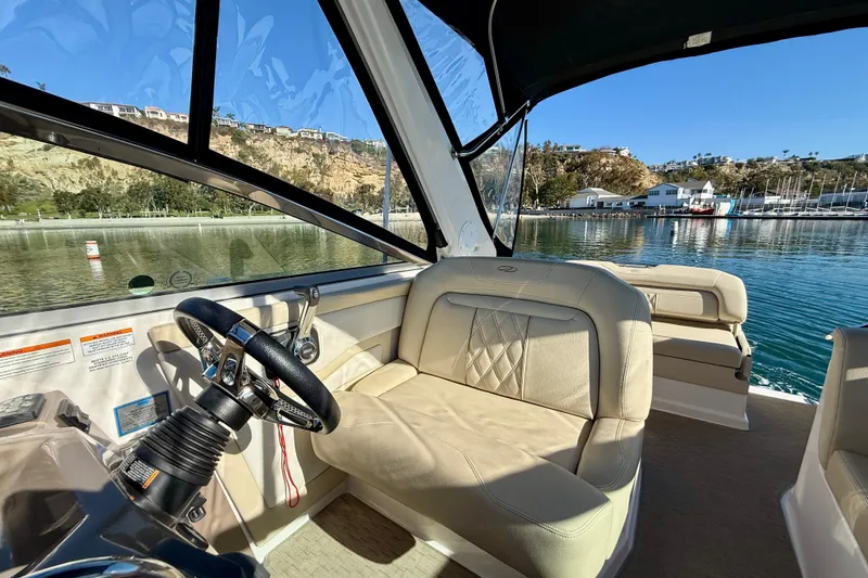 Slide: The Image of Interior of 2018 Regal 28 Express boat with beige seating and steering wheel. - 11