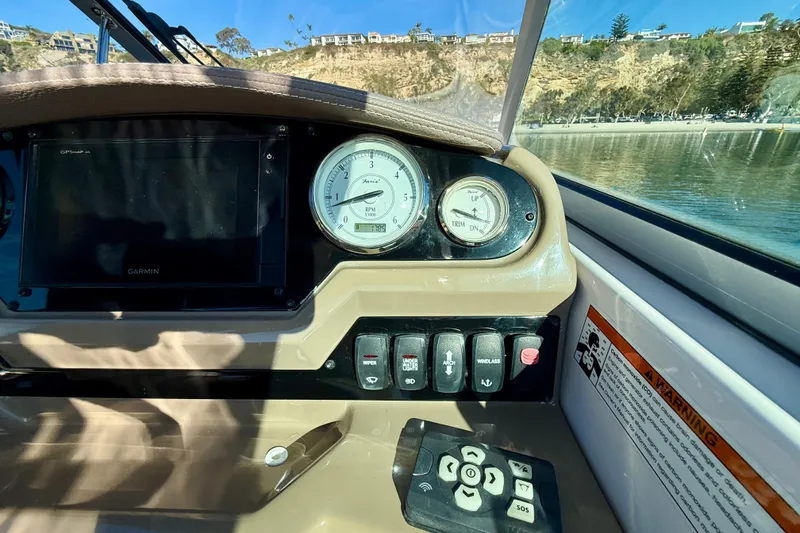 Slide: The Image of 2018 Regal 28 Express boat dashboard with gauges and controls, scenic background. - 12