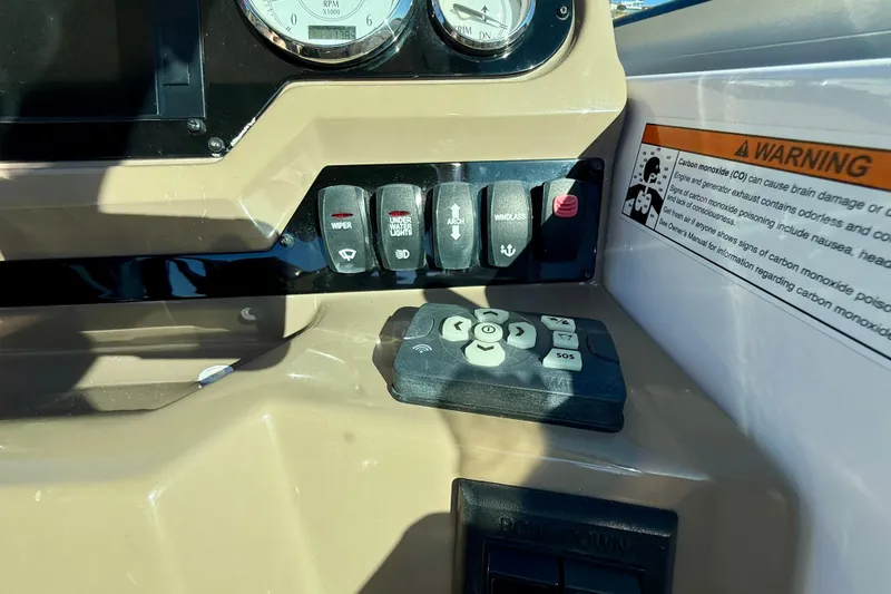 Slide: The Image of Control panel of a 2018 Regal 28 Express boat with warning label and switches. - 13