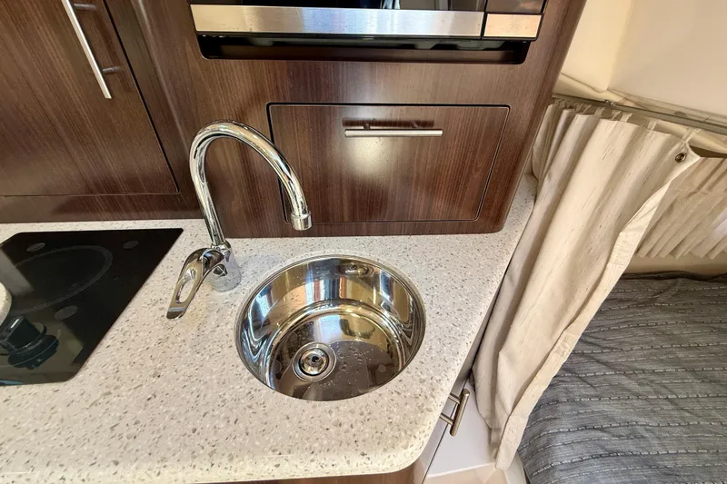 Slide: The Image of Compact kitchen area in 2018 Regal 28 Express boat with sink and countertop. - 15