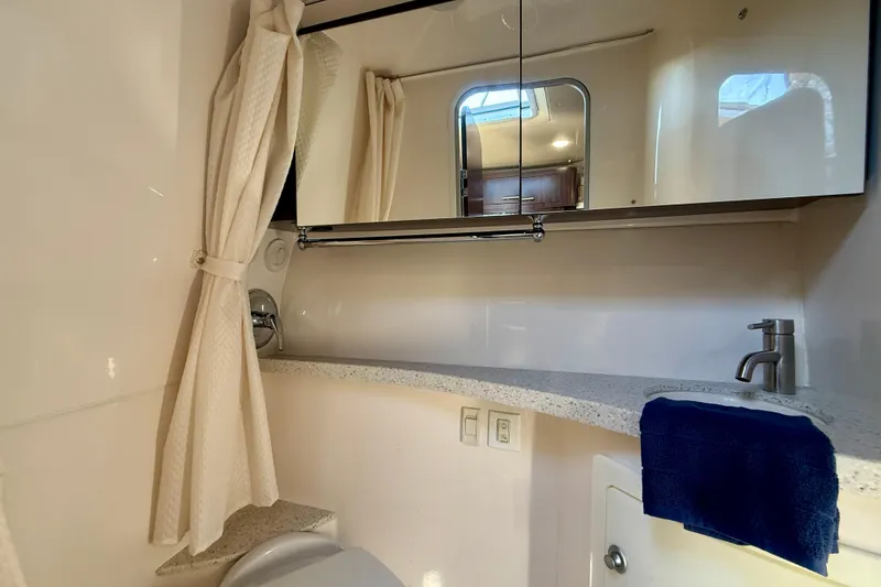 Slide: The Image of Bathroom interior of 2018 Regal 28 Express boat with mirror, sink, and shower curtain. - 19