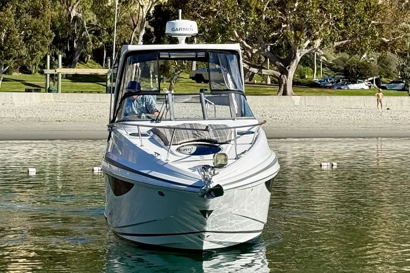 Slide: The Image of 2018 Regal 28 Express boat on calm water near a sandy beach. - 2
