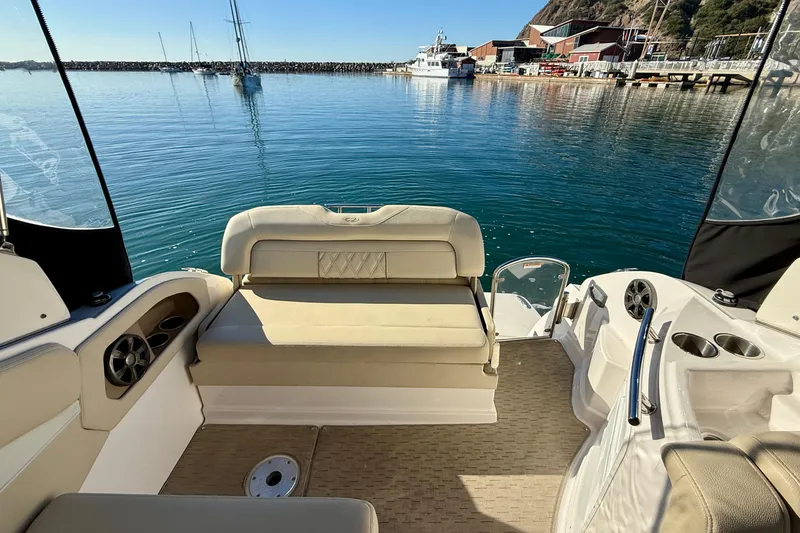 Slide: The Image of 2018 Regal 28 Express boat interior with seating, docked in a serene marina. - 30