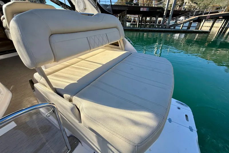Slide: The Image of 2018 Regal 28 Express boat seat with beige upholstery by the water. - 31