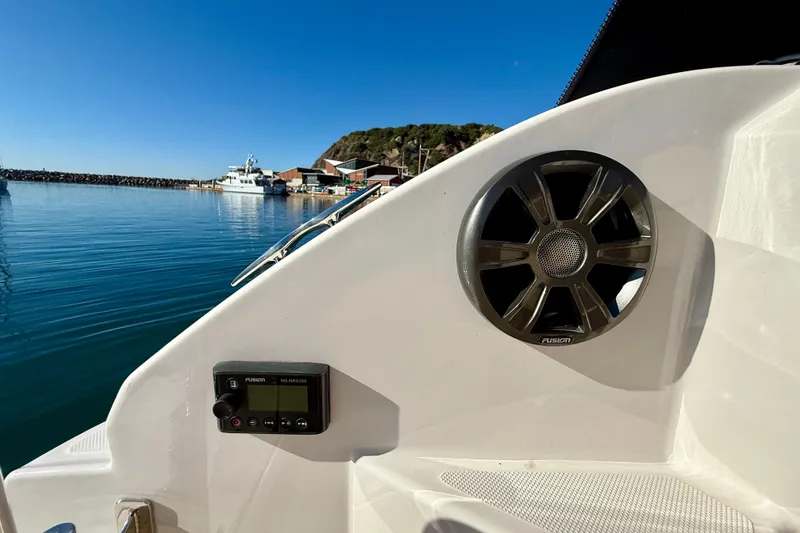 Slide: The Image of 2018 Regal 28 Express boat interior with speaker and control panel, docked in a serene harbor. - 37