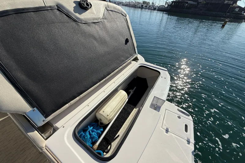 Slide: The Image of Open storage compartment on 2018 Regal 28 Express boat by the water. - 39
