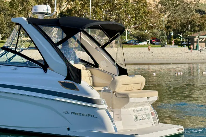 Slide: The Image of 2018 Regal 28 Express boat docked near a scenic beach. - 4