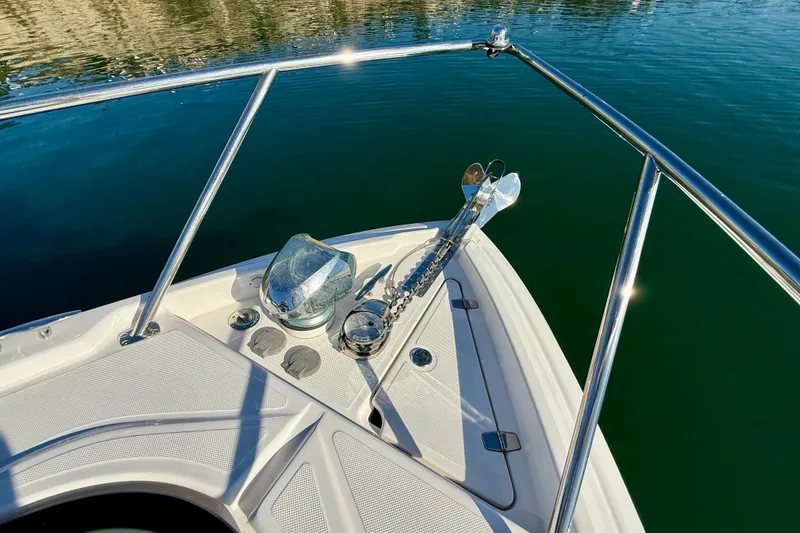 Slide: The Image of Bow of 2018 Regal 28 Express boat with anchor and railing on calm water. - 40