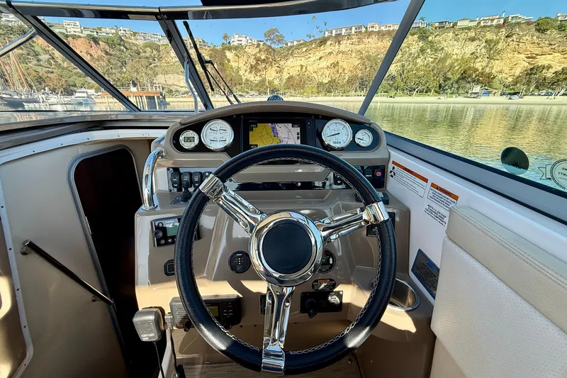 Slide: The Image of Cockpit view of 2018 Regal 28 Express boat with steering wheel and dashboard controls. - 6