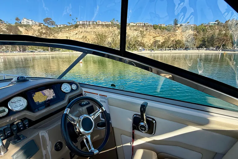 Slide: The Image of Cockpit view of 2018 Regal 28 Express boat with scenic waterfront background. - 8
