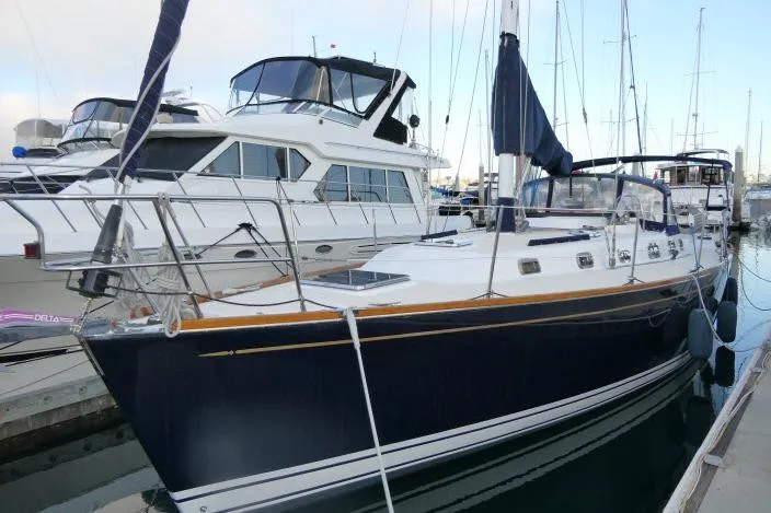 The Image of 2002 Tartan 3700 sailboat docked at marina, featuring sleek design and blue hull. - 1