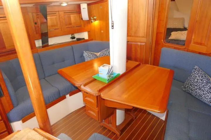 Slide: The Image of Interior of 2002 Tartan 3700 sailboat with wooden furnishings and blue seating. - 10