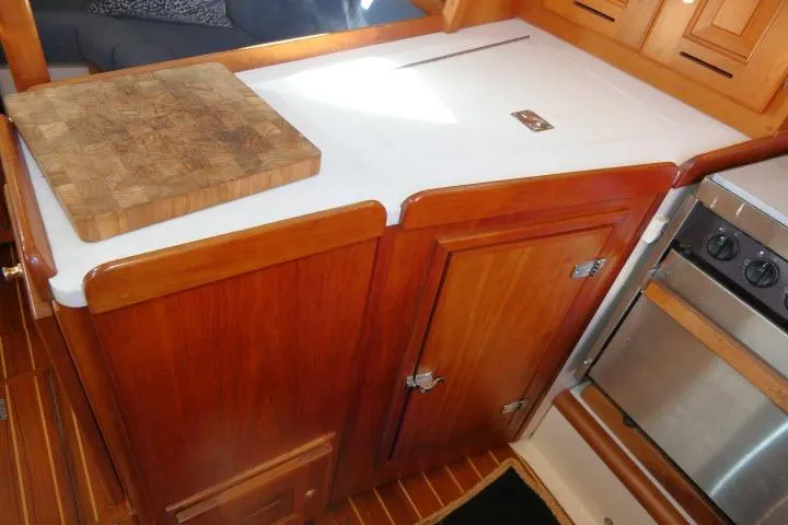 Slide: The Image of Wooden galley kitchen in 2002 Tartan 3700 yacht with cutting board and stove. - 14