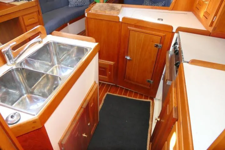 Slide: The Image of 2002 Tartan 3700 yacht interior with wooden cabinetry and dual sink. - 19