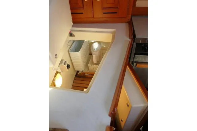 Slide: The Image of Interior view of 2002 Tartan 3700 sailboat, featuring wooden cabinetry and storage area. - 23