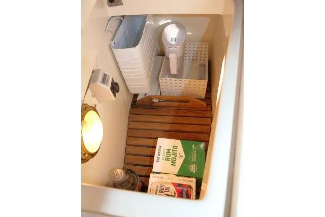 Slide: The Image of Storage compartment in a 2002 Tartan 3700 yacht with various items and a light. - 24