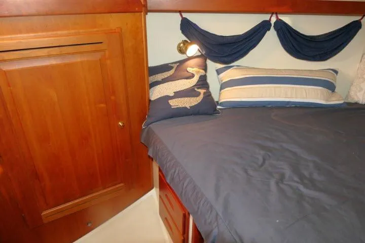 Slide: The Image of Cozy cabin interior of 2002 Tartan 3700 sailboat with nautical-themed bedding. - 30