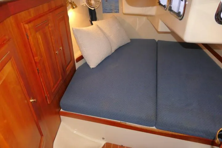 Slide: The Image of Cozy cabin interior of 2002 Tartan 3700 sailboat with blue bedding and wooden cabinetry. - 33
