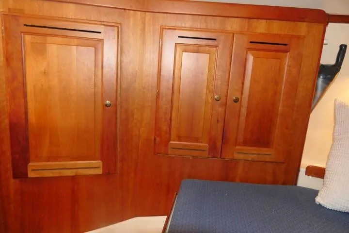 Slide: The Image of Wooden cabin interior of 2002 Tartan 3700 sailboat with blue cushioned seating. - 35