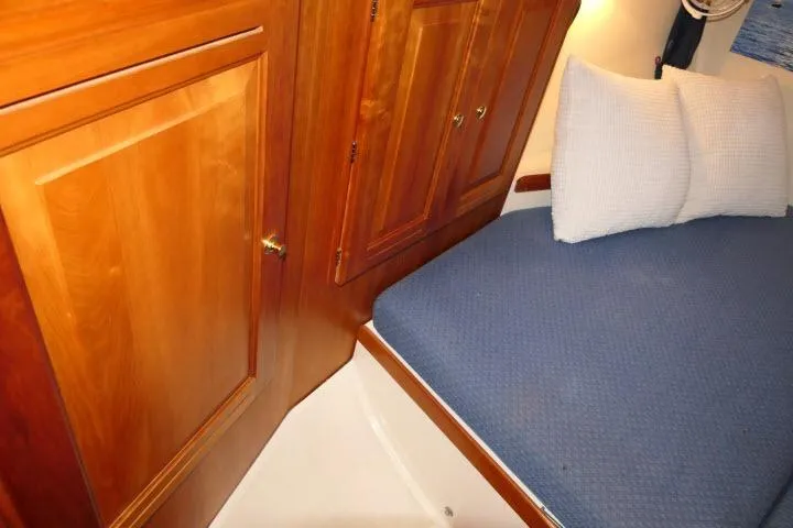 Slide: The Image of Cozy cabin interior of 2002 Tartan 3700 sailboat with wooden cabinetry and blue bedding. - 36