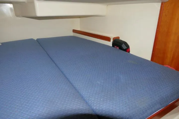 Slide: The Image of Interior cabin of 2002 Tartan 3700 sailboat with blue cushioned berth. - 38