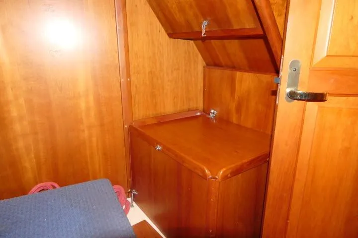 Slide: The Image of Wooden interior of a 2002 Tartan 3700 sailboat, featuring storage compartments and a door. - 39