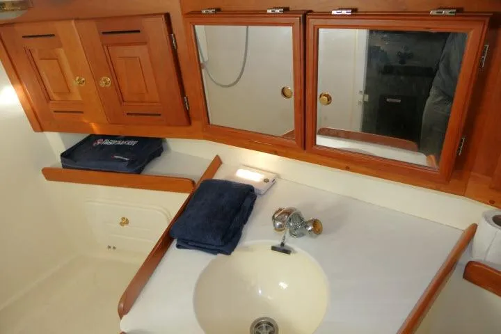 Slide: The Image of Bathroom vanity in 2002 Tartan 3700 yacht with wooden cabinets and mirror. - 42
