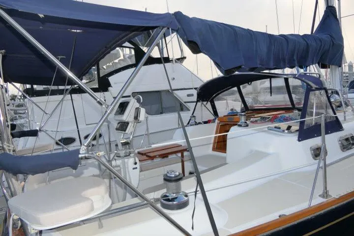 Slide: The Image of 2002 Tartan 3700 sailboat docked at marina, featuring covered cockpit and sleek design. - 46