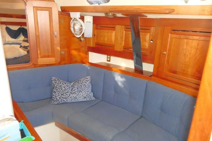 Slide: The Image of Cozy interior of 2002 Tartan 3700 sailboat with blue seating and wooden cabinetry. - 7