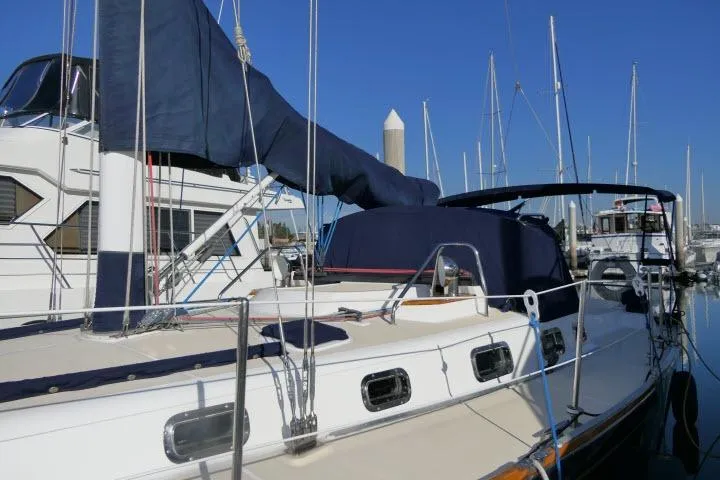 Slide: The Image of 2002 Tartan 3700 sailboat docked at marina with blue covers and clear sky. - 75