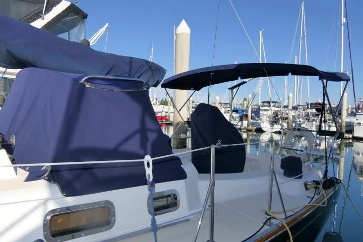 Slide: The Image of Sailboat Tartan 3700, 2002 model, docked at marina with blue covers and clear sky. - 76