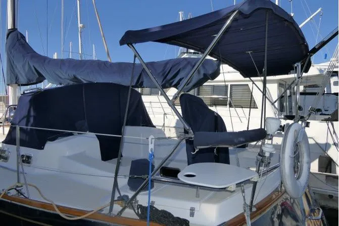 Slide: The Image of 2002 Tartan 3700 sailboat docked, featuring blue covers and a spacious deck. - 77