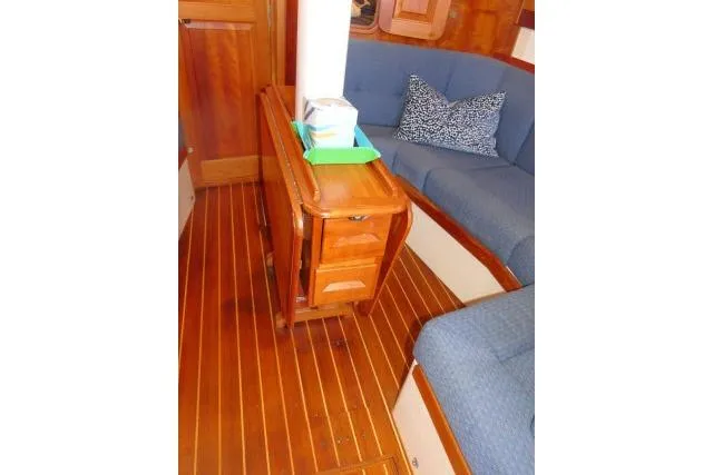 Slide: The Image of Interior of 2002 Tartan 3700 sailboat with wooden flooring and blue seating. - 8