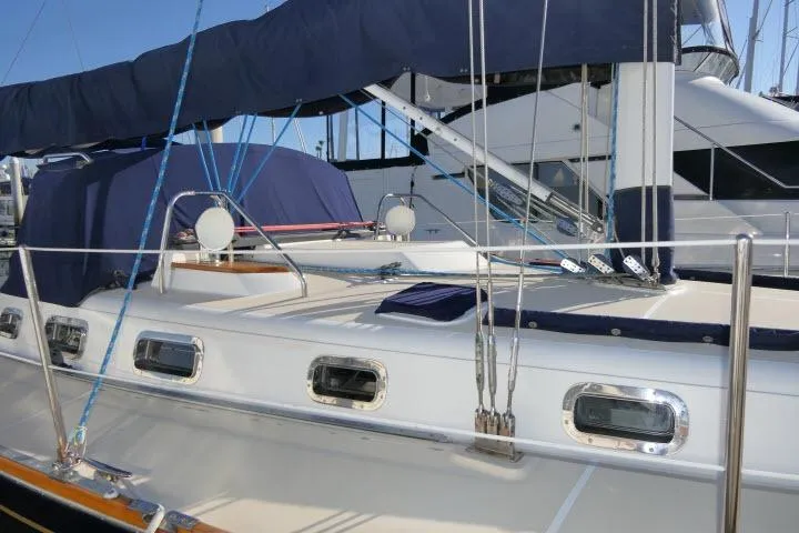 Slide: The Image of 2002 Tartan 3700 sailboat deck with blue covers and rigging in marina. - 82