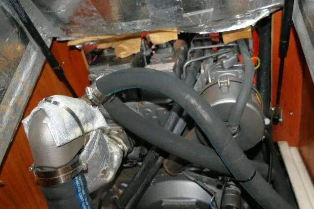 Slide: The Image of Engine compartment of a 2002 Tartan 3700 sailboat, featuring hoses and mechanical components. - 86