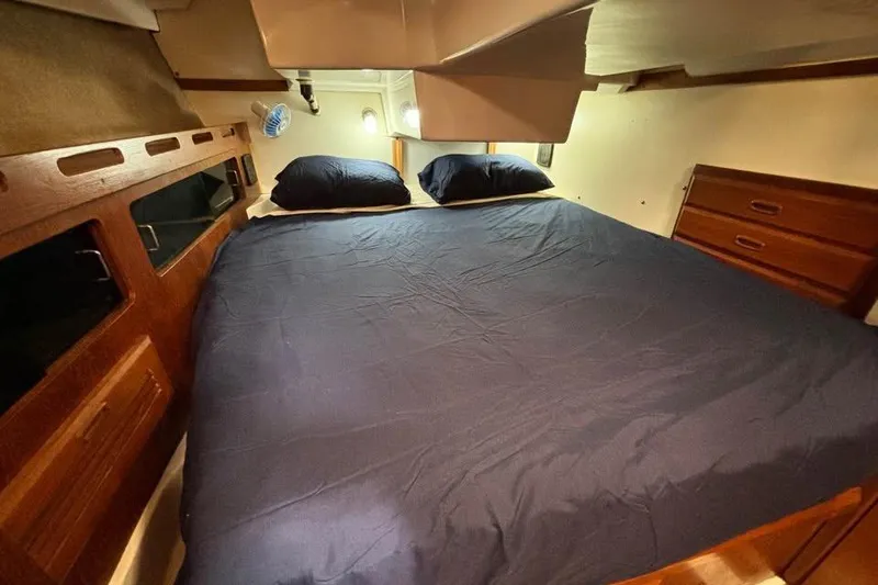 Slide: The Image of Cozy cabin interior of 1986 Hunter Legend 45 sailboat with double bed and wooden storage. - 10