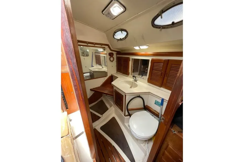 Slide: The Image of Interior of 1986 Hunter Legend 45 sailboat bathroom with wooden accents and porthole windows. - 11