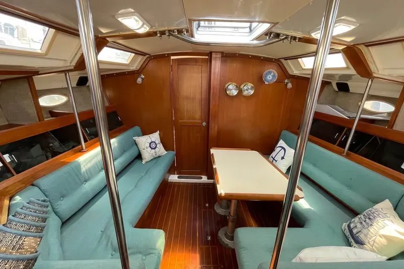 Slide: The Image of Interior of 1986 Hunter Legend 45 sailboat with teal seating and wooden accents. - 14