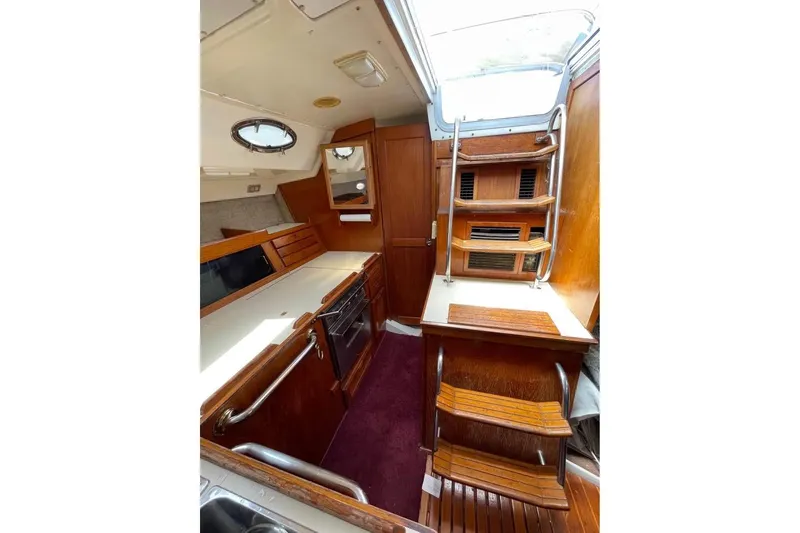 Slide: The Image of Interior of 1986 Hunter Legend 45 sailboat with wooden cabinetry and compact kitchen area. - 5