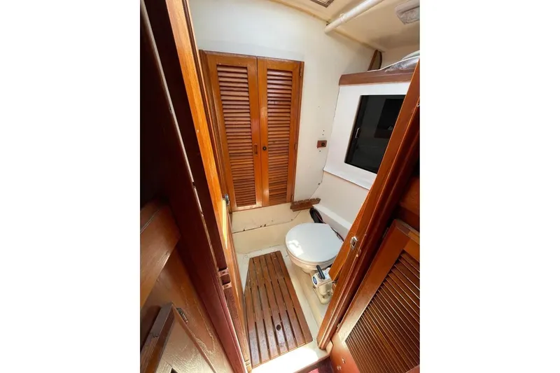 Slide: The Image of 1986 Hunter Legend 45 yacht bathroom with wooden accents and compact design. - 6