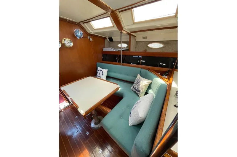Slide: The Image of Interior of 1986 Hunter Legend 45 sailboat with teal seating and wooden accents. - 8