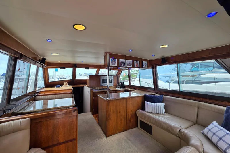 Slide: The Image of Interior of 1987 Hatteras 52 Convertible yacht with wood finishes and plush seating. - 12