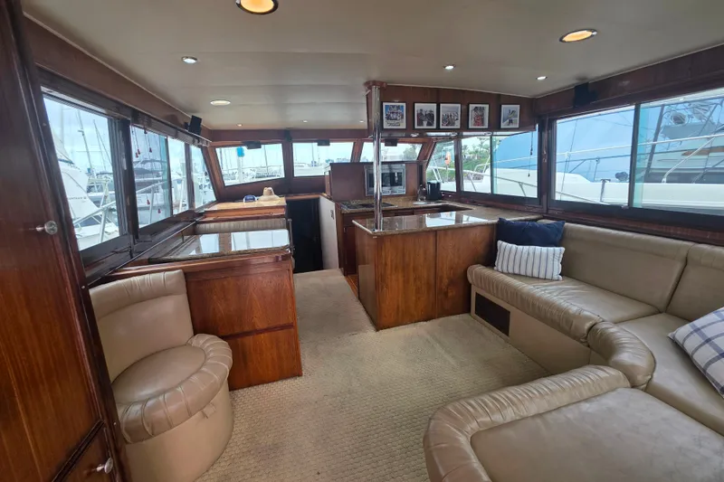 Slide: The Image of Luxurious interior of a 1987 Hatteras 52 Convertible yacht with plush seating and wood finishes. - 14