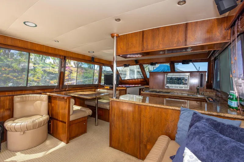 Slide: The Image of Interior of 1987 Hatteras 52 Convertible yacht with wood finish and seating area. - 2