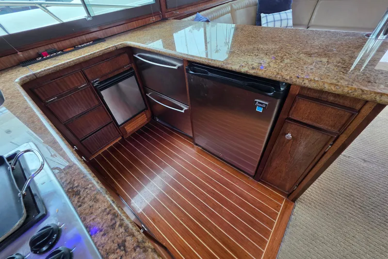 Slide: The Image of Luxurious kitchen interior of 1987 Hatteras 52 Convertible yacht with wood cabinetry and granite countertops. - 20